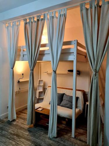 a bedroom with a bunk bed with blue curtains at Incantevole appartamento a Torino! in Turin