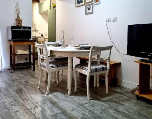 a white dining room table with chairs and a tv at Incantevole appartamento a Torino! in Turin