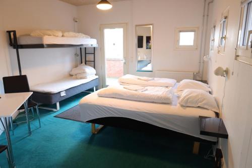 Zimmer mit 3 Etagenbetten und einem Tisch in der Unterkunft Motel Sindal in Sindal
