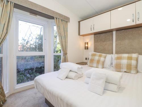 a bedroom with a large white bed with a window at Aquila in Morpeth