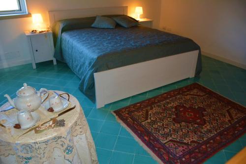 um quarto com uma cama e uma mesa com um conjunto de chá em Casale Dionisia a Castellabate, Appartamento Fico em Santa Maria di Castellabate