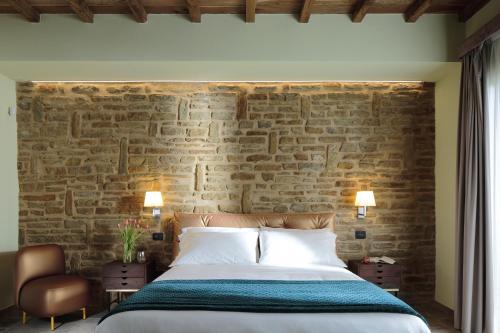 a bedroom with a bed and a brick wall at Villa Antica Dimora - Homelike Villas in Deruta