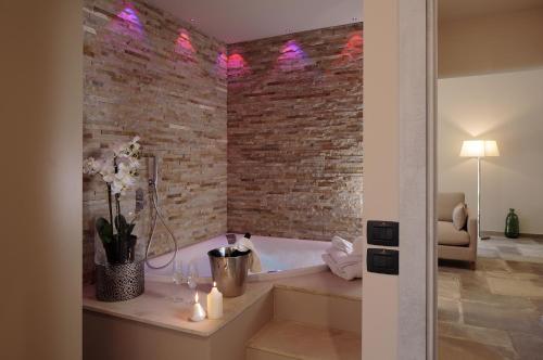 a bathroom with a brick wall and a bath tub at Villa Antica Dimora - Homelike Villas in Deruta