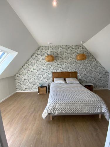 una camera mansardata con letto e parete di Maison Plogoff- Baie des Trépassées a Plogoff