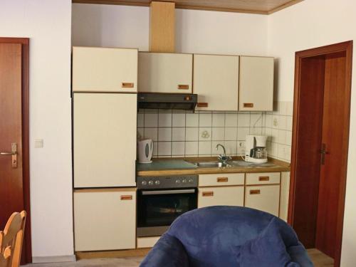 een keuken met witte kasten en een fornuis met oven bij Zur Dorfschänke in Medebach