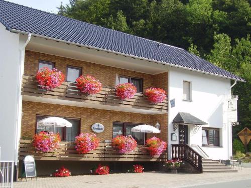 ein Gebäude mit Blumenkästen auf den Balkonen mit Sonnenschirmen in der Unterkunft Zur Dorfschänke in Medebach