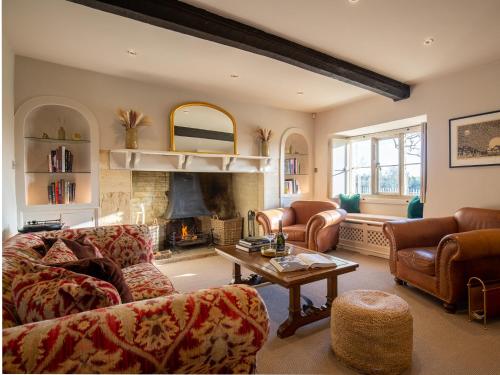 a living room with a couch and a fireplace at Green Farm House in Cirencester