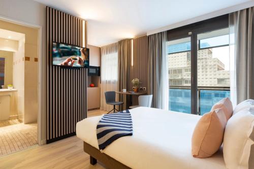 a hotel room with a bed and a flat screen tv at Citadines La D&eacute;fense Paris in Courbevoie