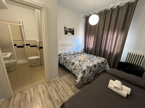フォリーニョにあるAffittacamere Umberto Iのベッドとバスルーム付きのホテルルームです。