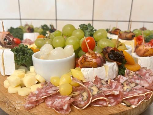 a plate of food with grapes and meat and cheese at Hotel i Restauracja „KRISTAL” in Braniewo