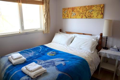 a bedroom with a bed with towels on it at Jenny Guest House in Yellowknife