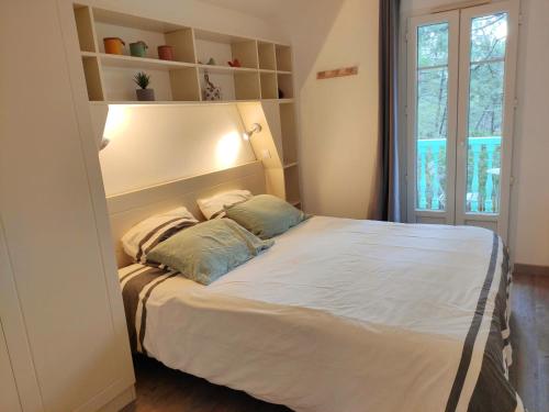 sypialnia z łóżkiem z 2 poduszkami w obiekcie Un Nid dans la Pinède w mieście Lacanau