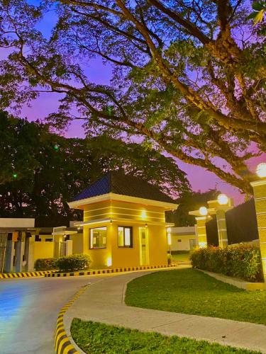 a large yellow house with a tree in front of it at Aurora Villas and Cabin Resort in Clark