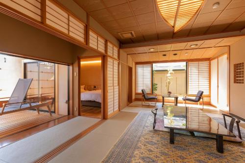 a living room with a glass table and a bed at Ichiraku tendo spa & brewery in Tendo