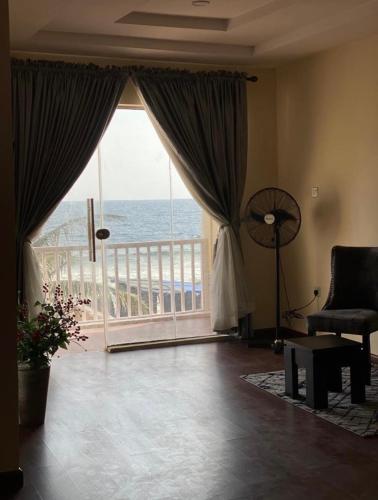 a living room with a large window with a view of the ocean at Oceanfront Wavecrest Hotel in Lekki