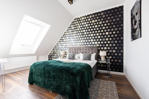 a bedroom with a bed and a wall with polka dots at THE Penthouse at Eco Smart Apartments in Nürnberg