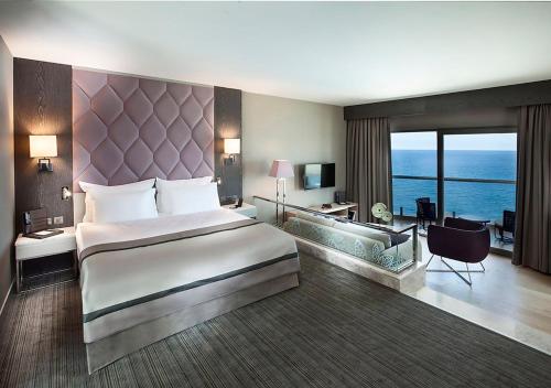 a bedroom with a large bed and a living room at Elexus Hotel Resort & Spa & Casino in Kérynia