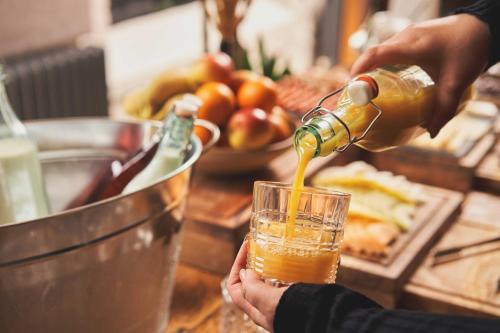 a person pouring a drink into a glass on a counter at Hope & Anchor in Hope-Cove