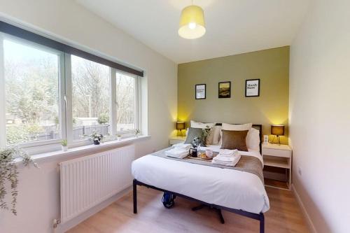 a bedroom with a bed and a window at Oakwell View - Modern 3 Bed Home in Barnsley