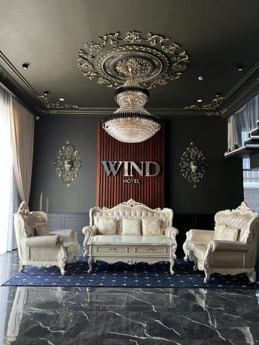 a living room with two white couches and a chandelier at WIND HOTEL in Shymkent