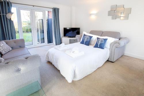 a bedroom with a large white bed and a couch at Dragonfly House in Maidenhead