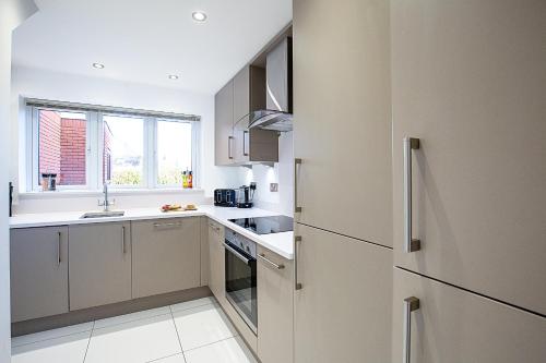 a kitchen with a refrigerator and a sink at Dragonfly House in Maidenhead
