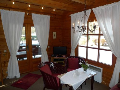 a dining room with a table and chairs and windows at Landhaus Meyer in Riefensbeek