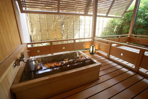 a large bath tub in a room with a window at Ichiraku tendo spa & brewery in Tendo
