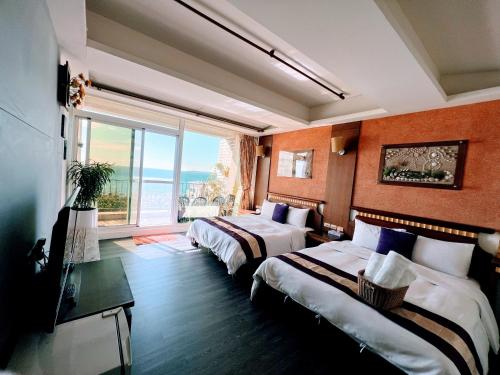 een hotelkamer met 2 bedden en een groot raam bij Ming Jun Homestay in Eluan