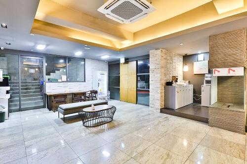 a lobby with a couch and a table and a refrigerator at Seomyeon Hound Hotel 1st Street in Busan