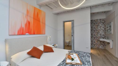 a bedroom with a bed with an orange painting on the wall at Cortile in Roccalbegna