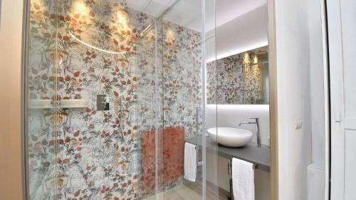 a bathroom with a glass shower and a sink at Cortile in Roccalbegna