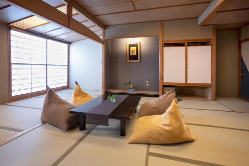 a living room with a table and pillows at Ichiraku tendo spa & brewery in Tendo