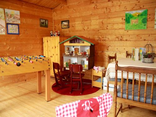 a room with a crib and a table and a bedroom at Andreashof in Heimenkirch
