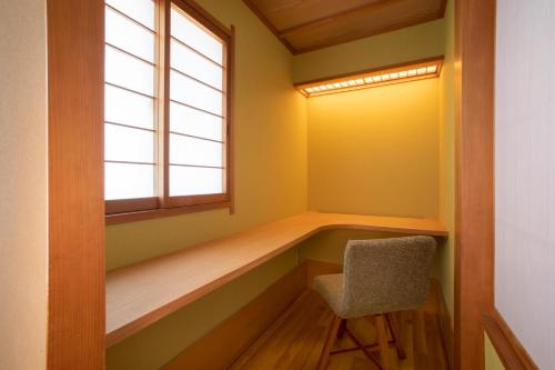 a room with a bench and a window and a chair at Ichiraku tendo spa & brewery in Tendo
