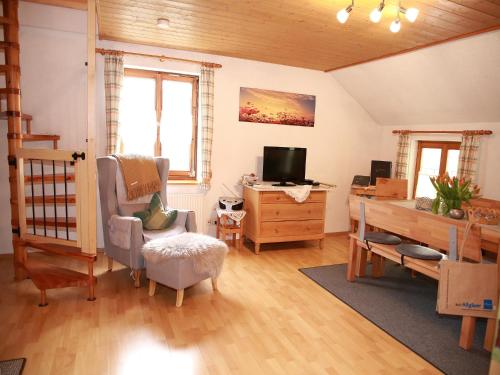 ein Wohnzimmer mit einem Schreibtisch und einem TV in der Unterkunft Andreashof in Heimenkirch