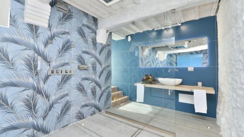 een badkamer met een blauwe muur en een wastafel bij Caciaia in Roccalbegna