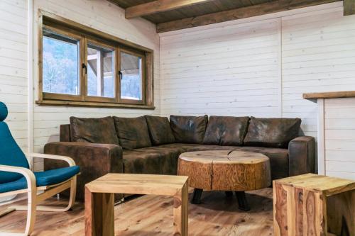 a living room with a leather couch and a table at Gombaszög in Gombasek