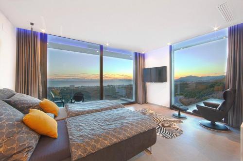 ein Schlafzimmer mit einem Bett und einem großen Fenster in der Unterkunft Luxury Villa Tomillo in Marbella