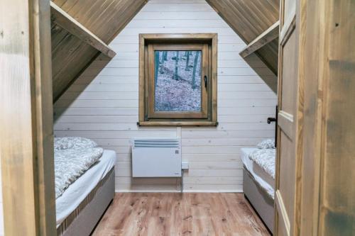 a tiny house with two beds and a window at Gombaszög in Gombasek