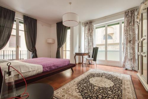 a bedroom with a bed and a table and windows at Apartments Florence Menicucci in Florence