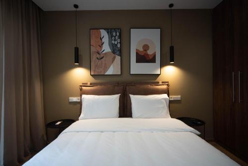 ein Schlafzimmer mit einem Bett mit zwei Bildern an der Wand in der Unterkunft Downtown Luxury Apartments 34 in Ioannina