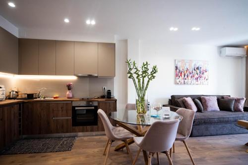 eine Küche und ein Wohnzimmer mit einem Tisch und einer Couch in der Unterkunft Downtown Luxury Apartments 34 in Ioannina