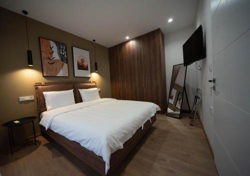 ein Schlafzimmer mit großem Bett und Flachbildfernseher in der Unterkunft Downtown Luxury Apartments 34 in Ioannina