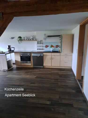 a large kitchen with wooden floors and appliances at Ferien Mecklenburgische Seenplatte, Urlaub auf dem Gutshof Bossow in Bossow