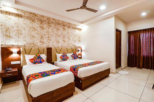 a hotel room with two beds and a window at FabHotel Rotano Grand - Nr Marathahalli Bridge in Bengaluru