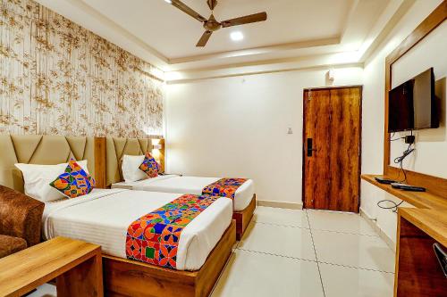 a hotel room with two beds and a television at FabHotel Rotano Grand - Nr Marathahalli Bridge in Bengaluru