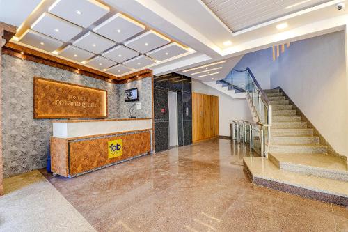 a lobby with stairs and a sign on the wall at FabHotel Rotano Grand in Bangalore