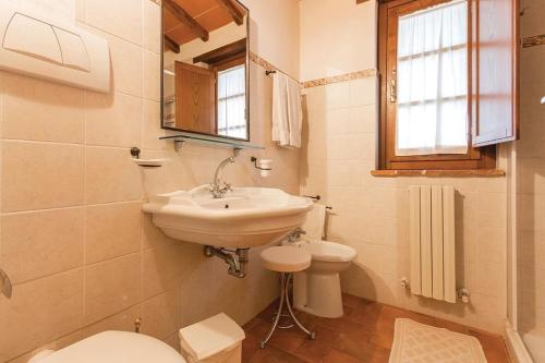a bathroom with a sink and a toilet and a mirror at L'Oasi della Pergola in Castiglione del Lago