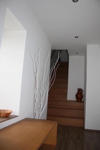 ein Wohnzimmer mit einer weißen Wand mit einem Baumbild in der Unterkunft K10 in Fußach